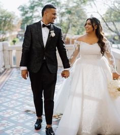 a bride and groom holding hands walking together