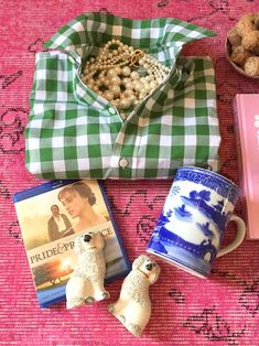 there are some items on the table including a book, coffee cup and teddy bear