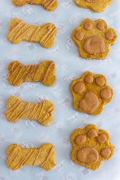 dog treats with peanut butter on them are arranged in the shape of paws and bones