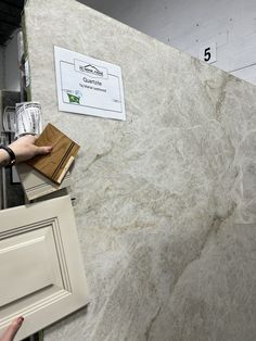 a marble counter top in a store with hand reaching for something on the counter next to it