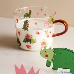 there is a glass cup with dinosaurs on it