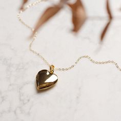 Keep love close to your heart with our Heart Locket Necklace. The 28mm gold-filled pendant, accompanied by an 18-inch chain gold-filled chain, combines classic elegance with a touch of sentimentality. It's a classic that's hard to beat! Gold Heart Locket Necklace 14k, Gold Heart Locket Necklace In 14k Gold, Gold 14k Locket Heart Necklace, Gold Minimalist Necklace For Keepsake, Gold Locket Necklace With Delicate Chain For Gift, Gold Delicate Chain Necklace For Anniversary, Classic Gold Heart Locket Necklace, 14k Gold Filled Necklaces For Valentine's Day, Classic Gold Locket Necklace With Heart Charm