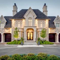 a large home with two garages and lots of windows on the front of it