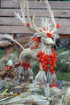 some kind of thing that is made out of straw and flowers on the back of a bench