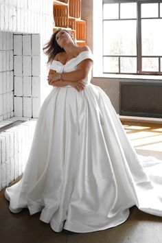 a woman in a white wedding dress posing for the camera