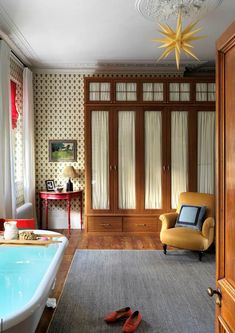 a bathroom with a bathtub, chair and closet