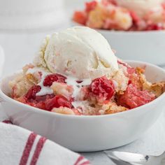 a bowl filled with ice cream and strawberries on top of a white tablecloth