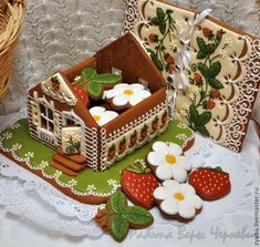 a close up of a cake with strawberries and cookies in the shape of a house