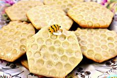 some cookies are on a plate with honeycombs and a bee sitting on top