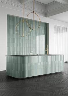 a modern kitchen with green tile and gold accents on the countertop, along with a chandelier hanging from the ceiling