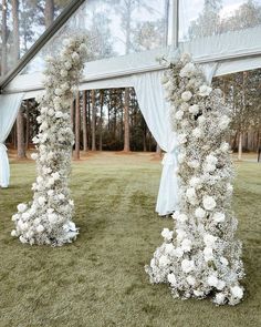 an outdoor ceremony with white flowers and drapes