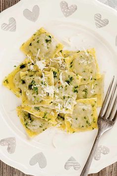 a white plate topped with ravioli and cheese