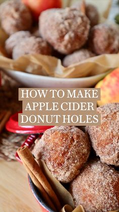 apples and cinnamon donuts in a bowl on a table next to some cinnamon sticks