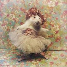 a stuffed animal in a tutu with flowers on it's head