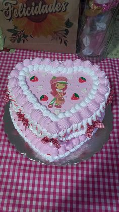 a heart shaped cake sitting on top of a checkered tablecloth covered table cloth