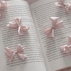 an open book with pink bows on it