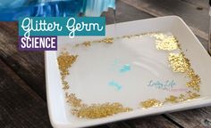 a white plate topped with gold glitter next to a jar of glue and scissors on top of a wooden table