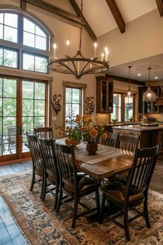 a dining room table with chairs and a chandelier hanging from it's ceiling