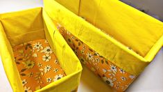 two yellow storage bins with flowers on them