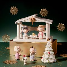 a group of figurines sitting on top of a wooden box next to a christmas tree