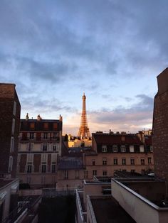 the eiffel tower is in the distance as seen from an apartment building's rooftop