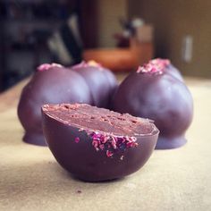 three pieces of chocolate with pink sprinkles on them sitting on a table