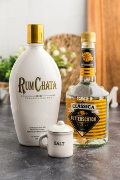 a bottle of rumchata next to a cup on a counter