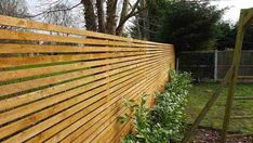 a wooden fence in the middle of a yard