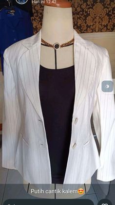 a mannequin wearing a white jacket and black top