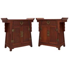 a pair of wooden side tables with brass hardware