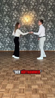 a man and woman standing in front of a wall with the words der hithamme on it