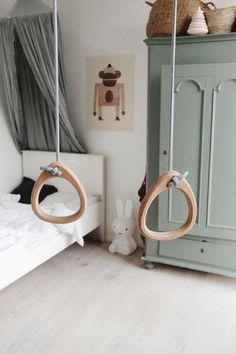 two wooden swings hanging from the ceiling in a bedroom