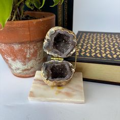 Absolutely stunning one-of-a-kind ring box is made from a natural geode cut in half and mounted on a piece of marble. This looks like it was handmade since you can see the epoxy that was used to attach the chain and hinge, as well as attaching it to the base. This is perfect for storing your wedding rings on your nightstand.  The way the crystal catches and reflects the light creates a mesmerizing, magical icy purple. The organic design is the ideal statement piece for your proposal or for that one friend you have that seems to already have everything. Measurements of this Geode are 3" tall x 3" long x 2.5" deep when opened. A truly unique piece! Pictures serve as part of item's condition/description. Geode Ring Box, Geode Ring, Purple Quartz, Crystal Geode, Organic Design, That One Friend, Treasure Boxes, Ring Box, Crystal Items