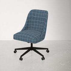 an office chair with wheels and a blue checkered upholstered fabric on the back