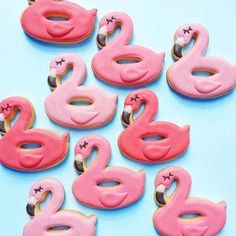 pink flamingo cookies are arranged in the shape of donuts on a blue background