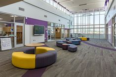 a large open room with couches, tables and chairs on the floor in front of windows