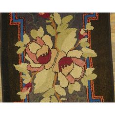 a rug with flowers on it sitting on top of a wooden floor