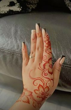 a woman's hand with henna tattoos on it