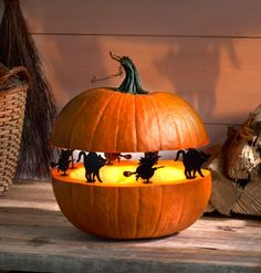 a carved pumpkin sitting on top of a wooden table next to a basket filled with stuffed animals