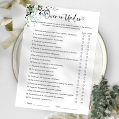 a wedding checklist with flowers and greenery next to it on a white plate