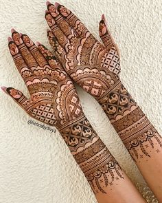 two hands with henna tattoos on them