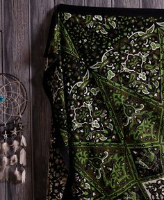 a green and black patterned fabric next to a dream catcher