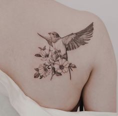 a woman's back with a hummingbird and flowers on it