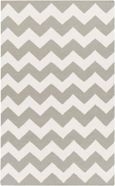 a gray and white rug with chevrons on it