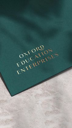 the oxford education enterprise's logo is shown on a green cover over a marble floor