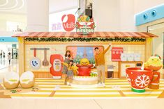 a man and two children are standing in front of a store with food items on display