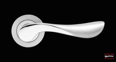 an artisticly designed door handle in polished stainless steel on a black background with the word,