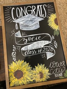 a chalkboard sign that says congrats with sunflowers