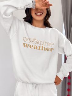 Bundle up, buttercup! Our "Sweater Weather" Sweatshirt is here to wrap you in a cozy embrace warmer than your ex's apology text. This isn't just a sweatshirt – it's a wearable ode to that magical time of year when leaves turn crisp and your dating standards turn flexible. Perfect for sipping pumpkin spice lattes, pretending to enjoy football, or aggressively cuddling your cat while scrolling through dating apps. With this sweatshirt, you're not just embracing autumn, you're practically french-ki White Winter Sweatshirt For Leisure, White Sweatshirt For Leisure, Winter Season, White Sweatshirt For Leisure In Winter, Super Soft Fleece Sweatshirt For Fall, White Sweatshirt For Fall Leisure, Winter Sweats Relaxed Fit Super Soft, Winter Sweats With Relaxed Fit And Super Soft Texture, Winter Sweats With Relaxed Fit And Super Soft, Super Soft Relaxed Fit Winter Sweats