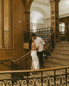 a man and woman are kissing on the stairs